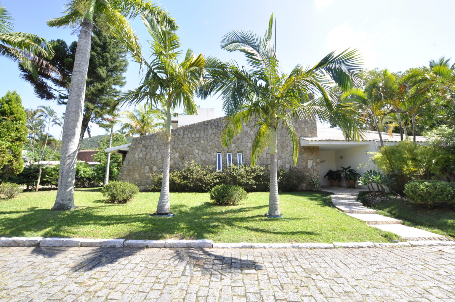 Casa em Condomínio Fechado na Lagoa da Conceição: com um terreno exclusivo de 1.980m² repleto de paisagismo exuberante.