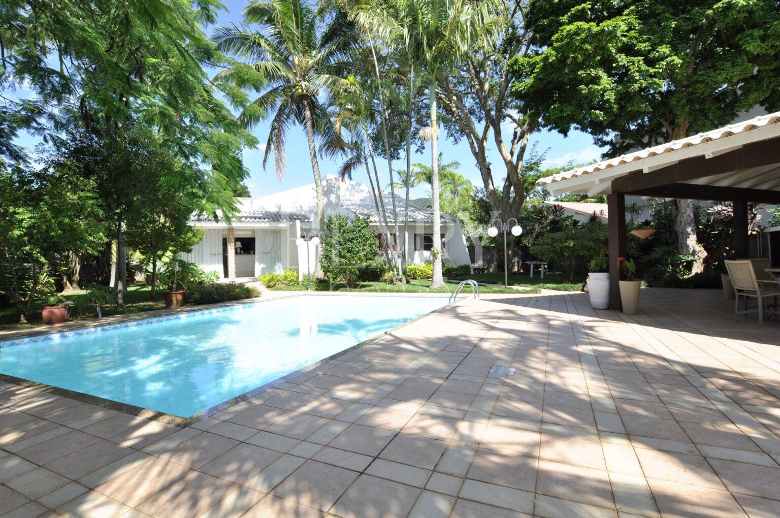 Casa em Condomínio Fechado na Lagoa da Conceição: com um terreno exclusivo de 1.980m² repleto de paisagismo exuberante.